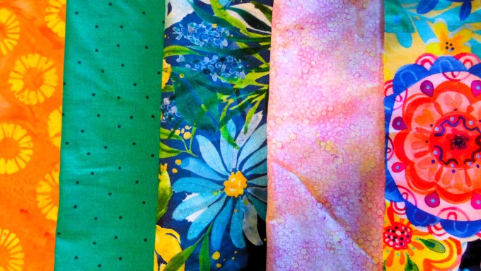Photo of brightly colored fabrics laid out in a row