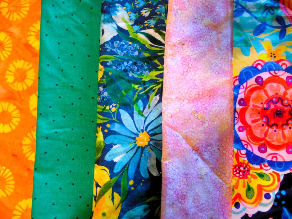 Photo of brightly colored fabrics laid out in a row